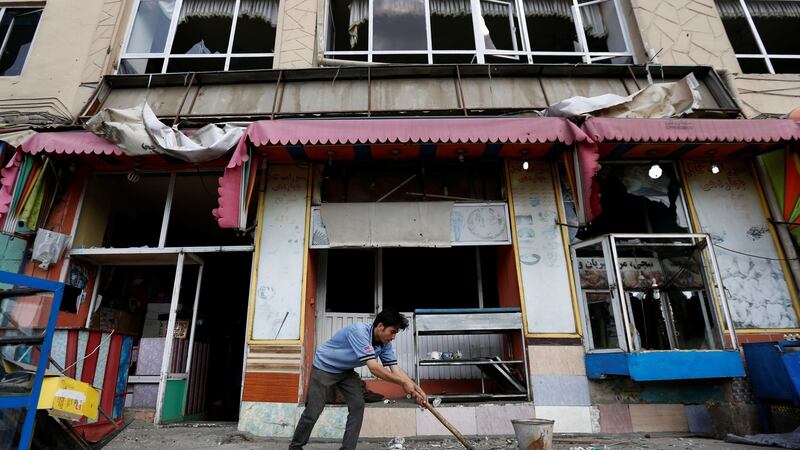 An Afghan man removes broken glass from his shop on Sunday, a day after a suicide attack in Kabul, Afghanistan. Photograph: Reuters