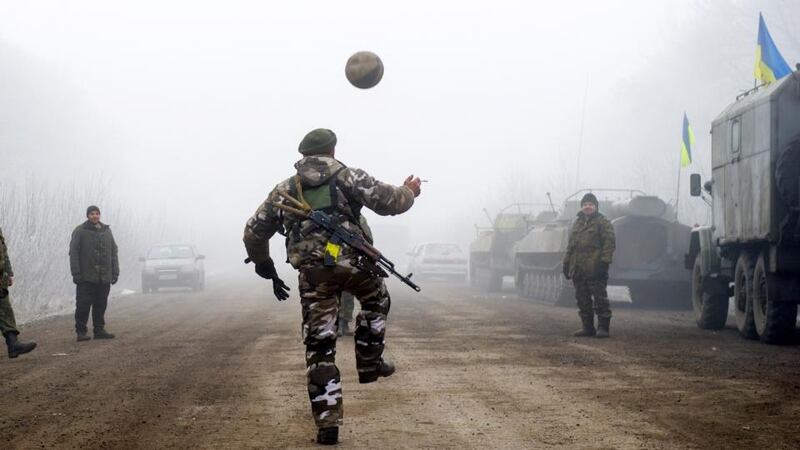 Ukrainian servicemen play football on a road at Svitlodarsk, approaching Debaltseve on Sunday. A ceasefire in Ukraine was cautiously observed by both sides, despite accusations by Kiev and the US that Russia had fuelled a final push by rebels to gain territory before the deadline. Photograph: Reuters