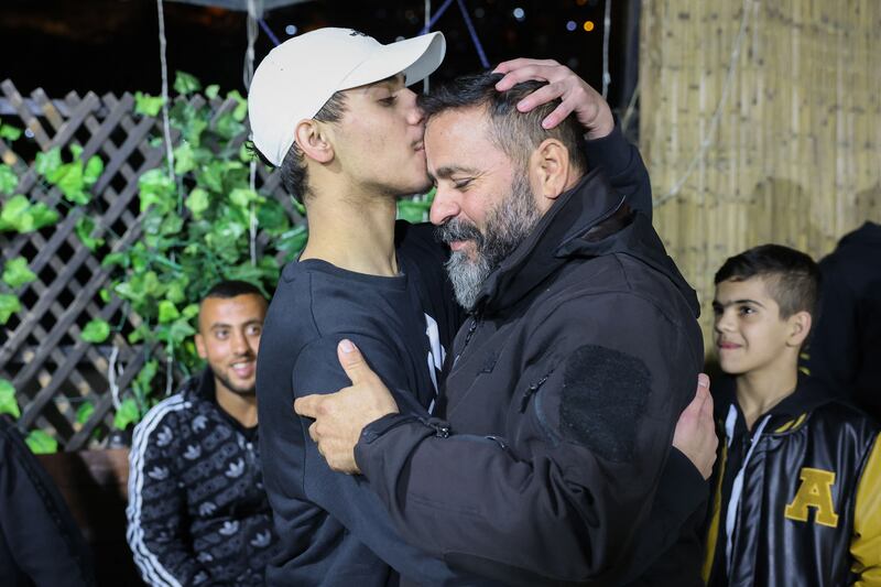 Palestinian Mohammed Al-Awar (left), former prisoner released from an Israeli jail in exchange for hostages freed by Hamas in Gaza, kisses his father's forehead upon return to his home in East Jerusalem, on Sunday. Photograph: Ahmad Gharabli/AFP via Getty Images