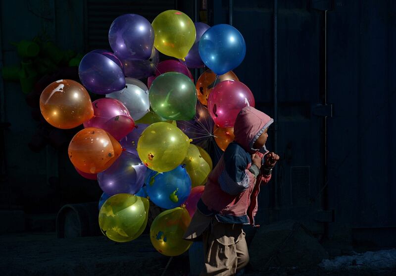 February 7th, 2013: An Afghan boy walks with balloons for sale on a cold winter’s day in Kabul. Photograph: Shah Marai/AFP