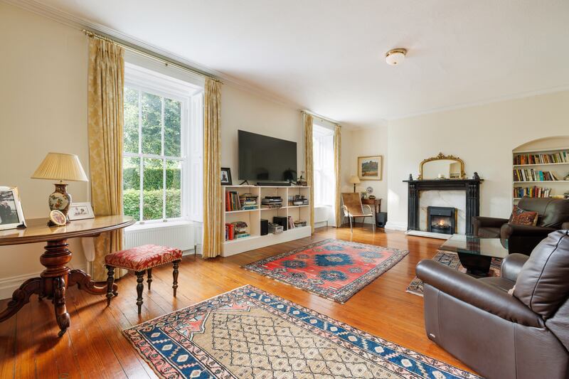 A pair of large reception rooms mirror each other: both have marble fireplaces and two big windows looking out to the magnificent views