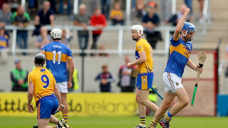 Tony Kelly looks on as John McGrath of Tipperary celebrates scoring a point. Photograph: James Crombie/Inpho