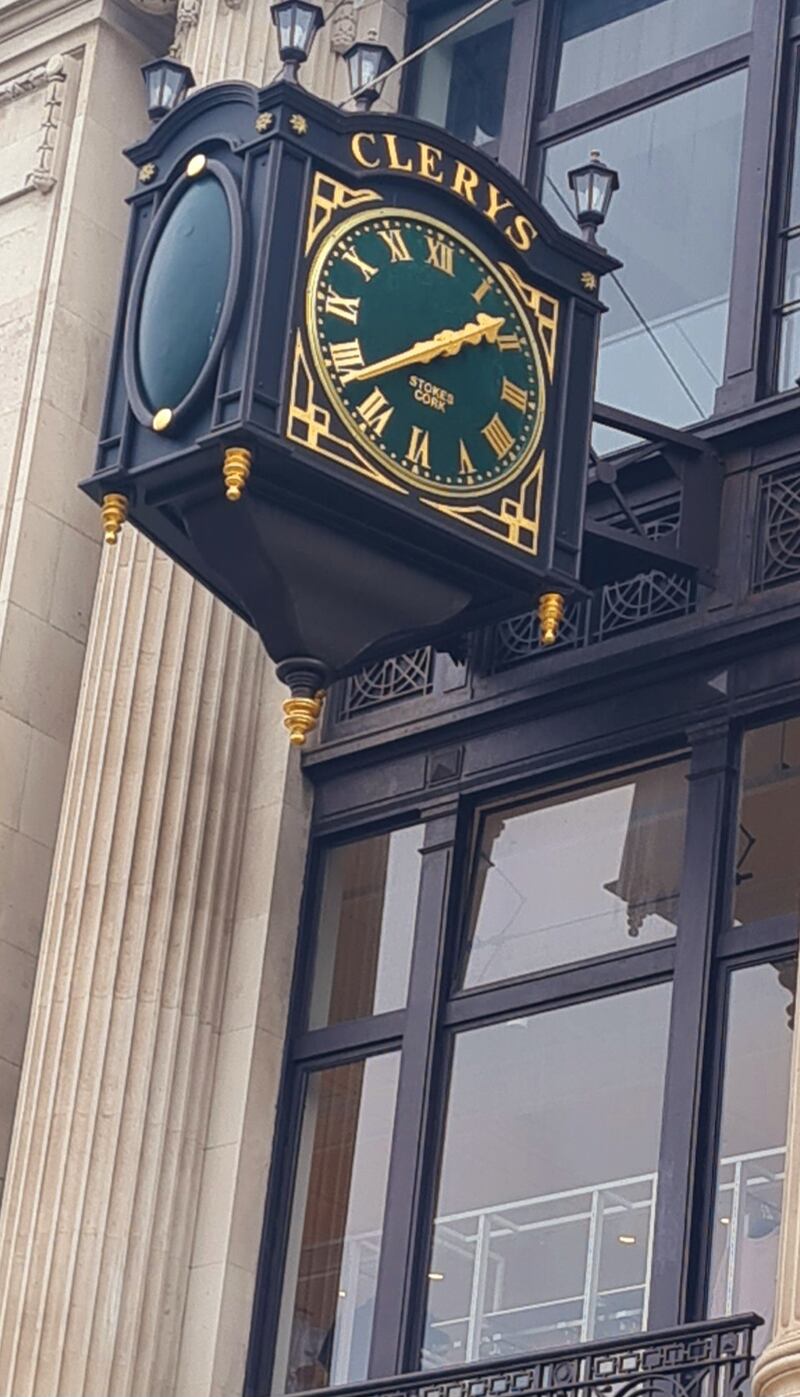 H&M clothing racks are visible through the first-floor windows below Clerys' famed clock