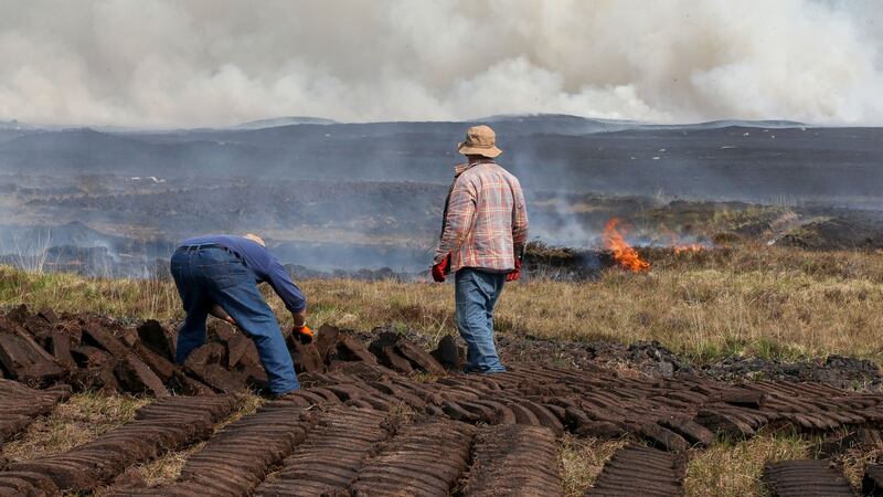 Footing turf near Seanafeistin as a gorse fire burns in Cloosh Valley, Connemara, on Tuesday. Photograph: Joe O’Shaughnessy