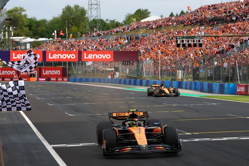 Lando Norris takes the chequered flag ahead of his McLaren team-mate Oscar Piastri. Photograph: Clive Rose/Getty Images