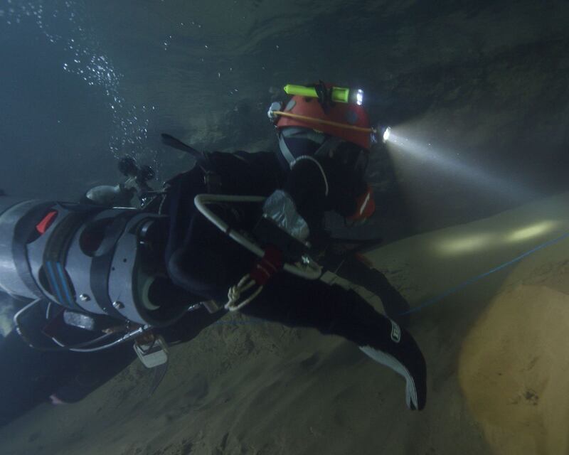 A diver swims through an underwater cave. Photograph: National Geographic