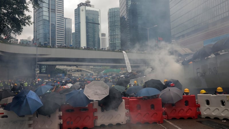 Protesters take cover  after police fired tear gas during an anti-government rally in Hong Kong, on Saturday.  Photograph: EPA