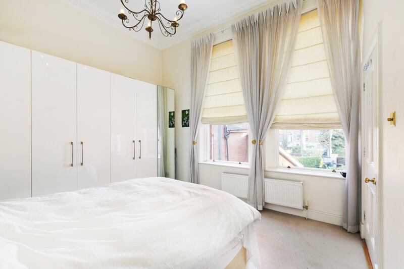 The second bedroom has built-in wardrobes and looks out to trees and Clyde Road beyond.