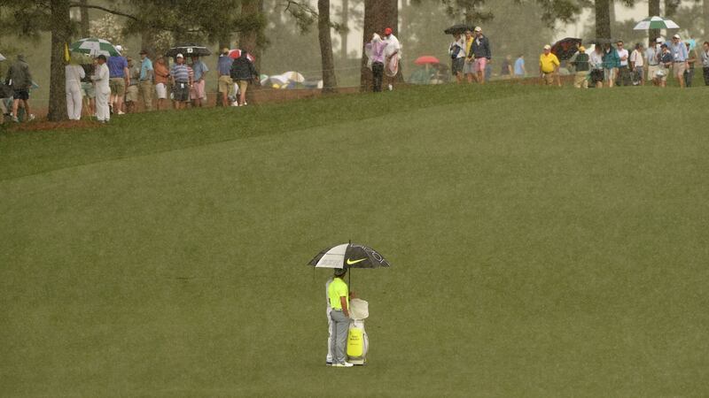 Rory McIlroy and caddie JP Fitzgerald take shelter from the rain during a practice round before last year’s US Masters. Photo: Getty Images