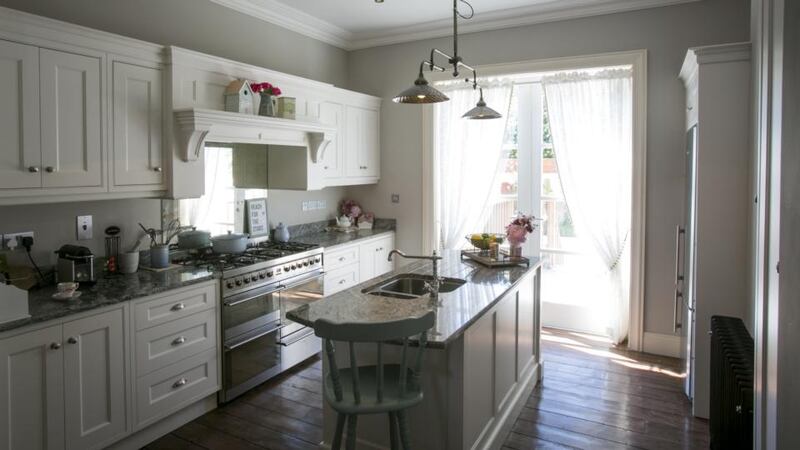 The kitchen, which is at hall-level, is a light-filled space with timber units topped with grey polished stone. Photographs: Paul Kelly Photography