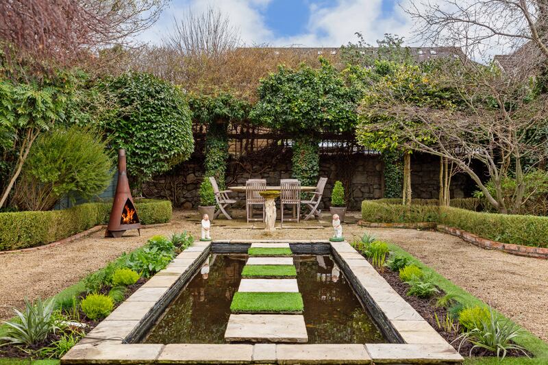 Garden with mature trees and stone pond