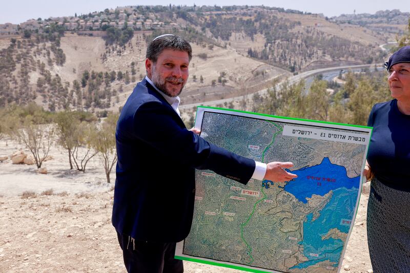 Israeli finance minister Bezalel Smotrich displays a map of an area near the settlement of Maale Adumim, a land corridor known as E1, outside Jerusalem in the occupied West Bank, on August 14, 2025, after a press conference at the site. Far-right ministers have openly called for Israel's annexation of the territory. Photograph: Menahem Kahana/ AFP via Getty Images   