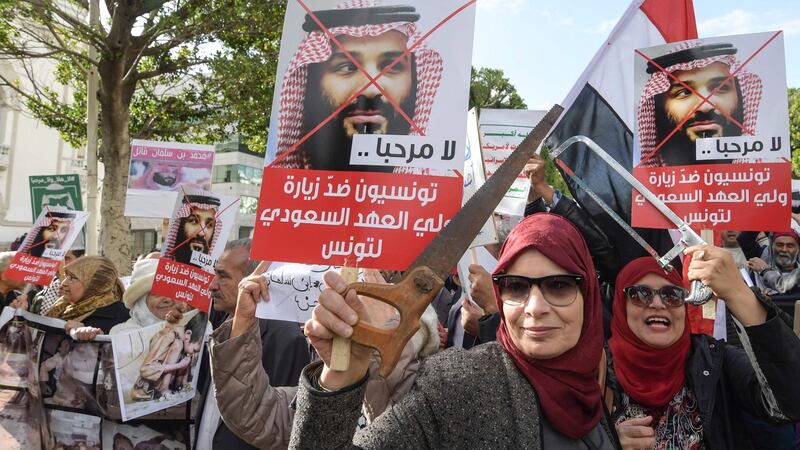Tunisian women hold up saws and signs showing pictures of Saudi Crown Prince Mohammed bin Salman with a caption below reading in Arabic “no welcome, Tunisians against the visit of the Saudi Crown Prince to Tunisia”, during an anti-Saudi Crown Prince protest  in the capital, Tunis on November 27th Photograph:  Fethi Belaid/ AFP/Getty