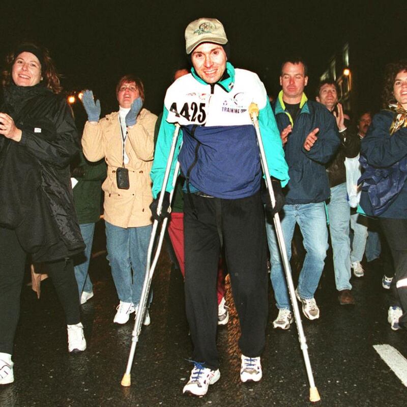 Stephen Le Rue from Chicago, surrounded by supporters as he crosses the finish line in 1998, after completing the marathon on crutches in just under 16 hours. Photograph: Eric Luke