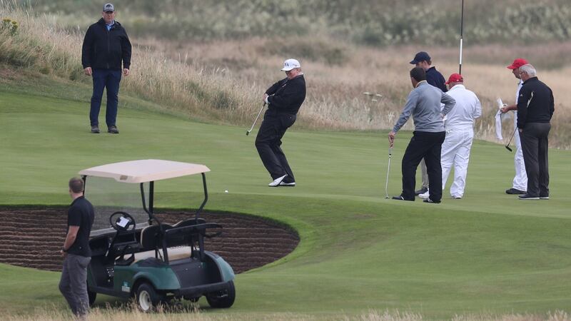 Trump attempts to steer a putt into the hole during his round. Photo: Andrew Milligan/PA Wire