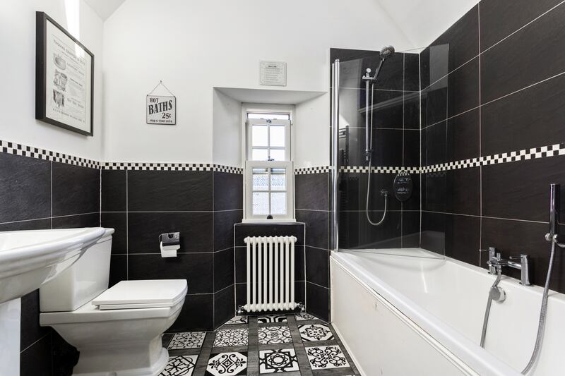 The family bathroom and has stained-glass double doors, plus a feature arch window above. Photograph: Alex Urdaneta