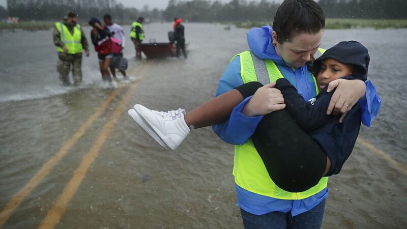 Volunteers  help rescue three children from their flooded home  in James City, US. Photograph: Chip Somodevilla/Getty Images