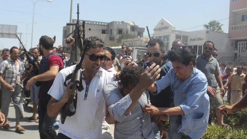 Police officers control the crowd while surrounding a man  suspected to be involved in an attack on a beachside hotel in Sousse, Tunisia. Photograph: Amine Ben Aziza/Reuters