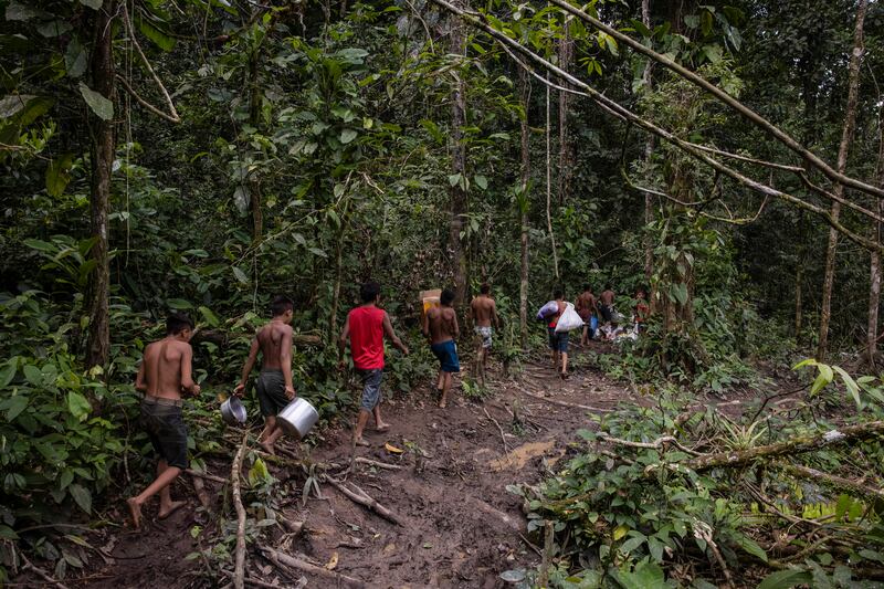 Yanomami people taking supplies from the miners’ camp back to their homes, Photograph: Victor Moriyama/The New York Times
                      