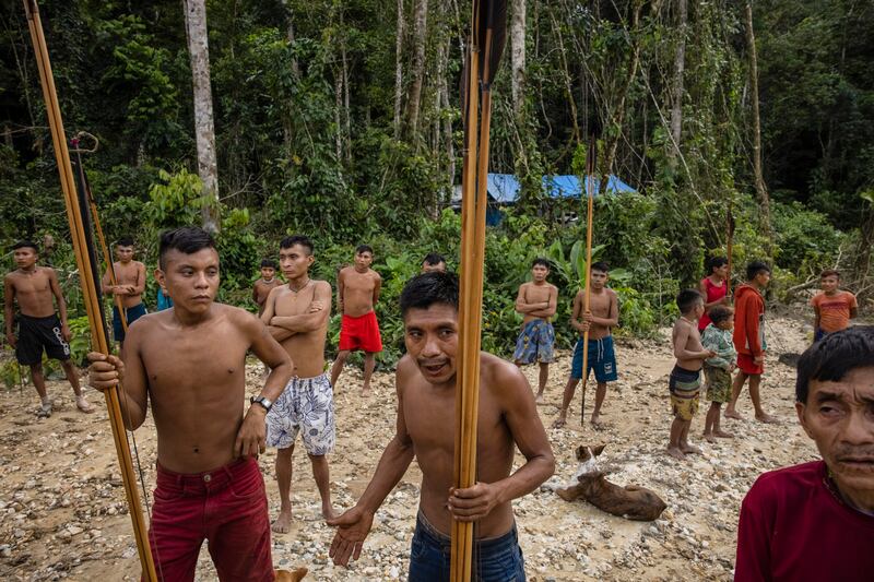 About two dozen Yanomami people, who emerged from the rainforest when members of Brazil’s environmental special forces team arrived to destroy illegal mining equipment in the Yanomami Indigenous territory of Brazil. Photograph: Victor Moriyama/The New York Times
                      