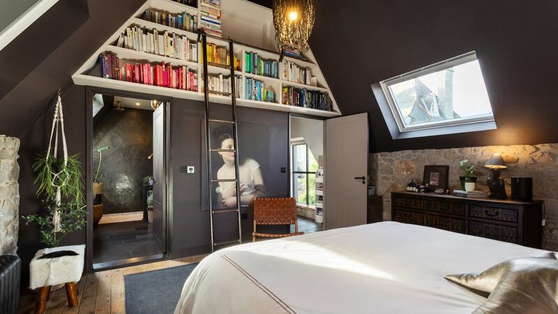 The built-in bookcases in the main bedroom at Glandore Mews are accessed via a library ladder.