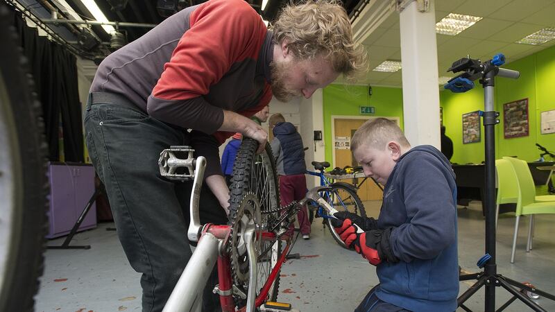 Bike mechanic Barry Semple working on a bike with Martin  at Bradog Youth Service. Photograph: Dave Meehan