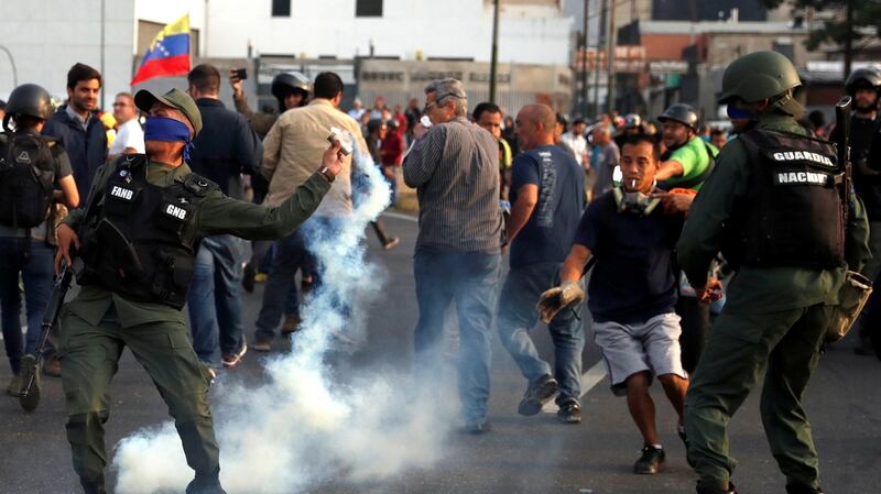 A military member throws a tear gas canister near the Generalisimo Francisco de Miranda Airbase La Carlota, in Caracas. Photograph: Carlos Garcia Rawlins/Reuters