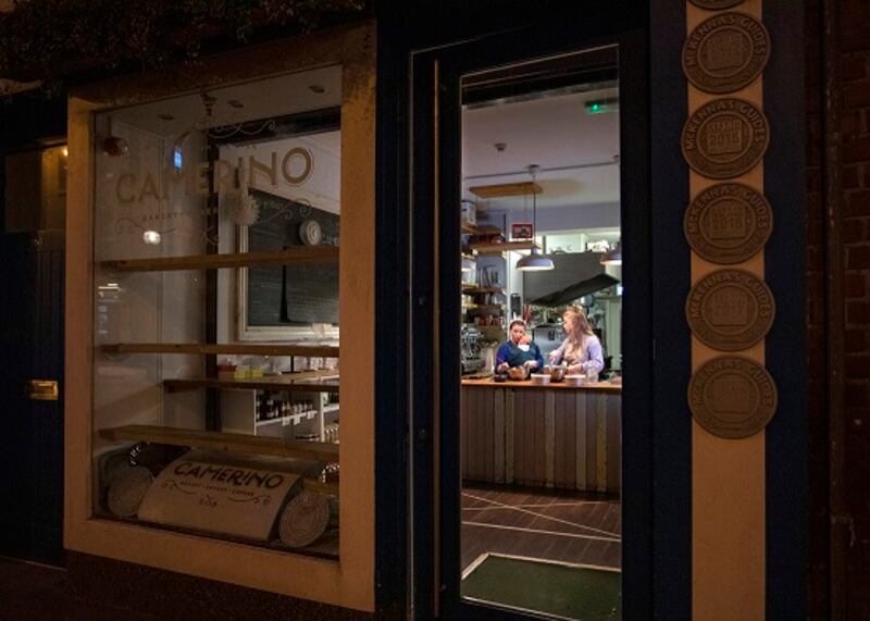 Caryna Camerino working at night in her Capel Street shop with her 12-week-old son Nico and step-daughter Sally. Photograph: Crispin Rodwell/The Irish Times