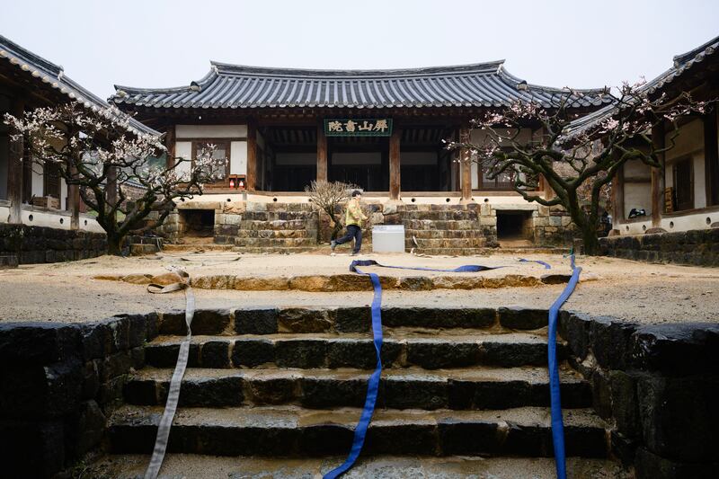 A firefighter walks past fire hoses on steps leading into the grounds of the Unesco-listed Byeongsan Seowon, a former Confucian academy, in Andong on March 27th, as firefighters spray water and fire-retardants on to the historic site in a bid to save it from possible approaching wildfires. Photograph: Getty Images   