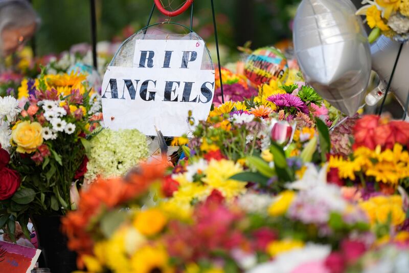 A sign amid flowers at a memorial at Annunciation Catholic Church after Wednesday’s school shooting. Photograph: Abbie Parr/AP