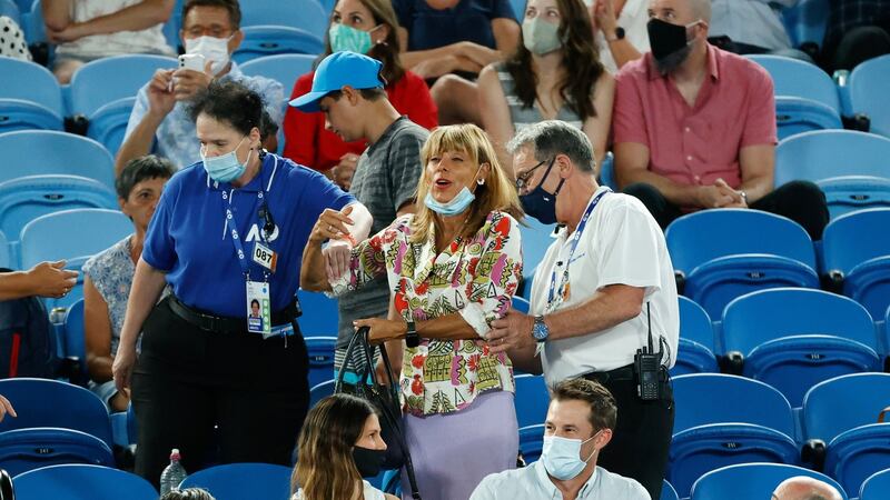 A spectator is escorted from Rod Laver Arena by security. Photo: Rick Rycroft/AP Photo