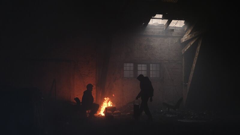 Migrants stand by a fire inside a derelict customs warehouse in Belgrade, Serbia. Photograph:   Marko Djurica/Reuters