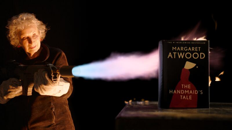 Margaret Atwood, 82, blasting a one-of-a-kind "unburnable" edition of The Handmaid's Tale with a flamethrower to test its fire-resistance. It sold at auction for $130,000 last month. The author attends Clifen Arts Festival in September