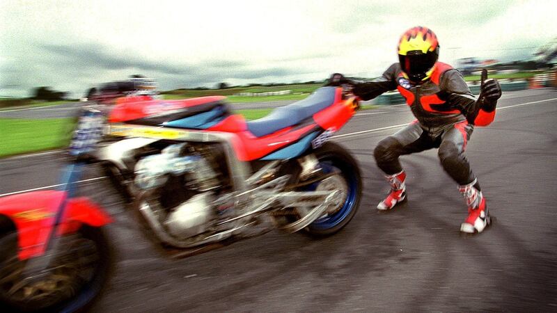 Motorcycle stunt rider Gary Rothwell slides along holding onto his stunt bike at speeds of 100mph at Mondello Park in August 1999. Photograph: David Sleator