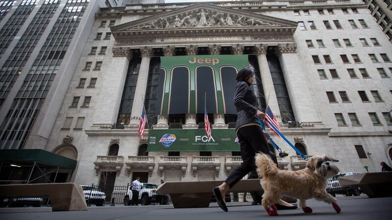 A woman walks a dog past the New York Stock Exchange (NYSE) in New York. Photograph: Michael Nagle/Bloomberg