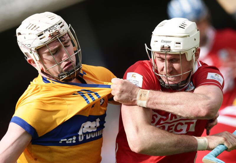 Clare's Adam Hogan and Tim O'Mahony of Cork struggle for possession. Photograph: Inpho
