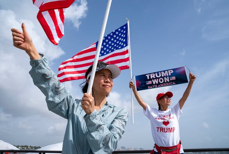 Trump supporters Eric He and HaoHao Li stand near Mar-a-Lago. Photograph: Greg Lovett/The Palm Beach Post/AP