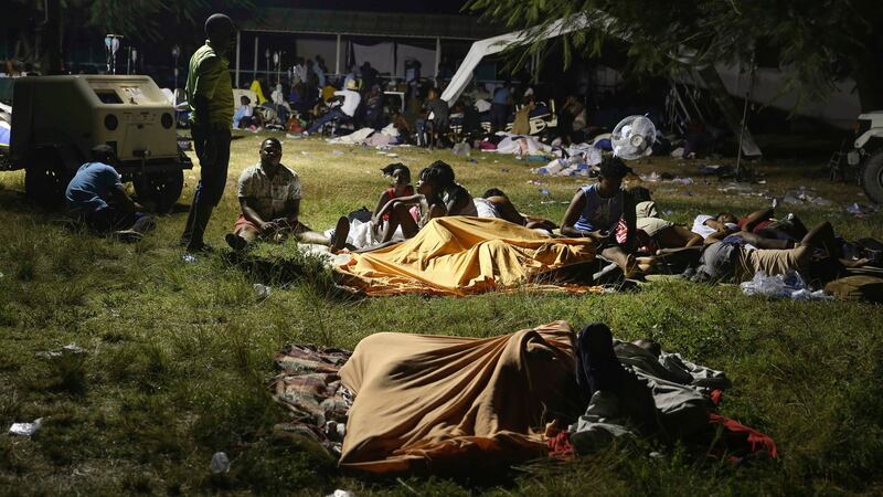 People displaced from their earthquake-destroyed homes spend the night outdoors in a grassy area in Les Cayes. Photograph: Joseph Odelyn/AP