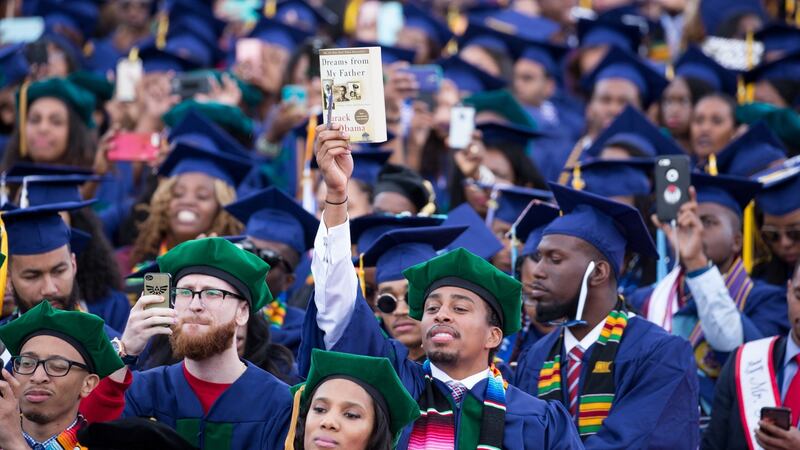 A  Howard University  graduate holds up  Barack Obama’s Dreams From my Father in Washington DC. Photograph:  Cheriss May/NurPhoto via Getty Images