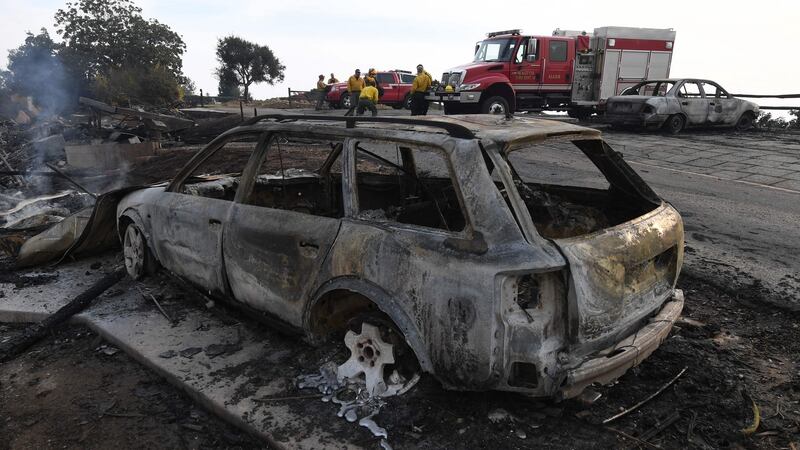 Firefighters investigate burnt out cars, as the Thomas wildfire continues to burn in Carpinteria, California on Sunday. Photograph: Mark Ralston/AFP