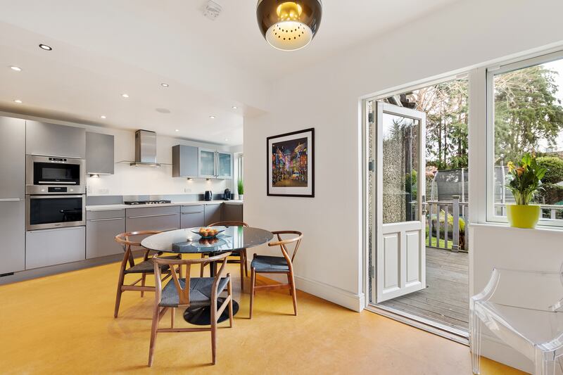 An eat-in kitchen in dark grey lies to the back of the property and opens to the back garden adjacent to a separate utility.