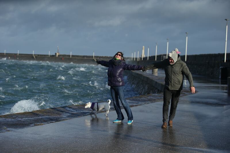 People take a brisk walk along Dún Laoghaire pier in windy conditions on Monday morning. Photograph: Stephen Collins/Collins
