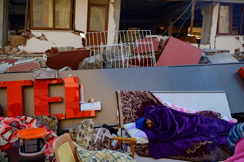 A man sleeps among the rubble of a collapsed building in Hatay, Turkey on February 10th. Photograph: Yasin Akgul/AFP via Getty