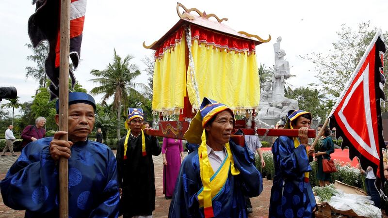 Vietnamese villagers, wearing traditional costume, carry a shrine past the monument during the 50th anniversary of the My Lai massacre in My Lai village, Vietnam March 15th, 2018. Photograph: REUTERS/Kham