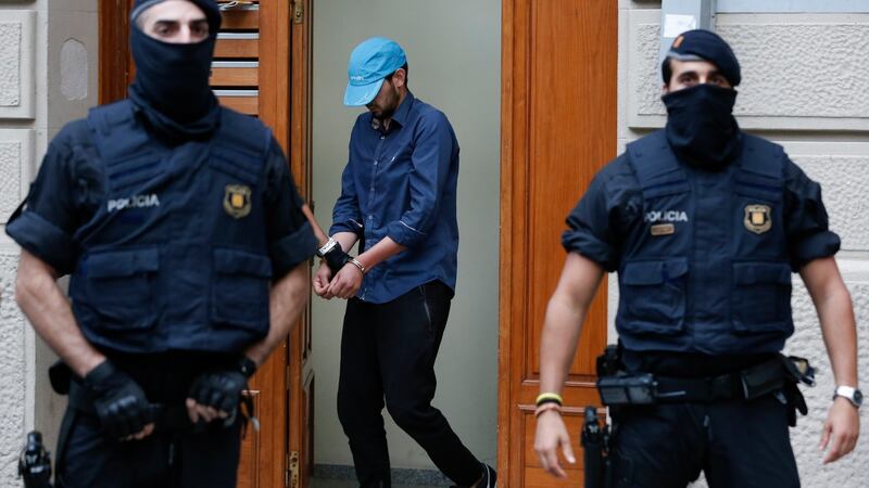 Catalan police officers detain a handcuffed suspect in Ripoll during a search linked to the terror attacks in Barcelona and the seaside resort of Cambrils on Friday. Photograph:  Pau Barrena/AFP/Getty Images