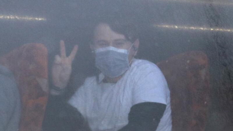 A passenger gives a peace sign as coaches carrying coronavirus evacuees arrive in Milton Keynes, after being repatriated to the UK from Wuhan in China. Photograph: Aaron Chown/PA Wire