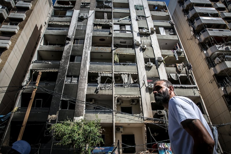 A man stands in front of a building hit by an air strike in Beirut's southern suburbs. Photograph: Sally Hayden