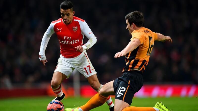 Alexis Sanchez of Arsenal is tackled by  Harry Maguire of Hull City during the FA Cup third round match  at Emirates Stadium. Photograph:  Paul Gilham/Getty Images