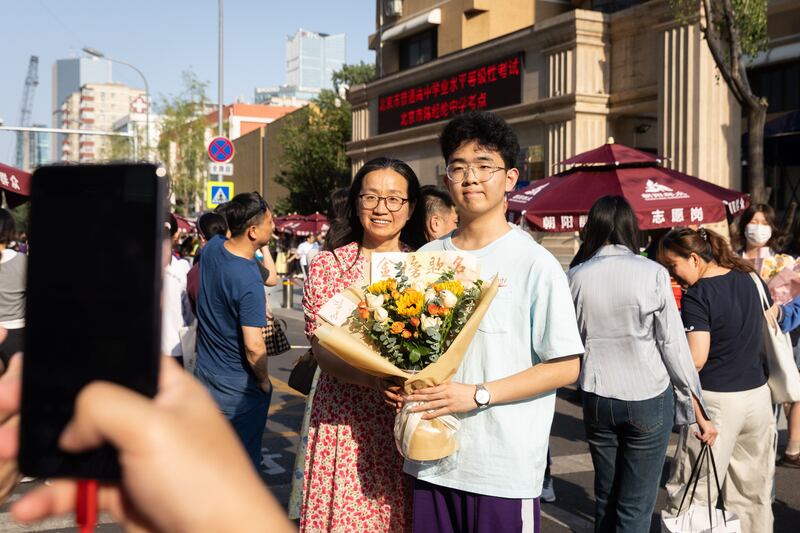 High school students and their families pose for photos after taking the gaokao in Beijing, China. The high-stakes, multi-day college entrance exam and determines a student's future path. Photo: EPA