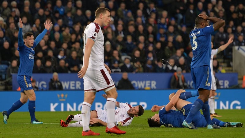 Burnley’s Robbie Brady and Leicester City’s Harry Maguire both go down injured after a collision. Photograph: Peter Powell/Reuters